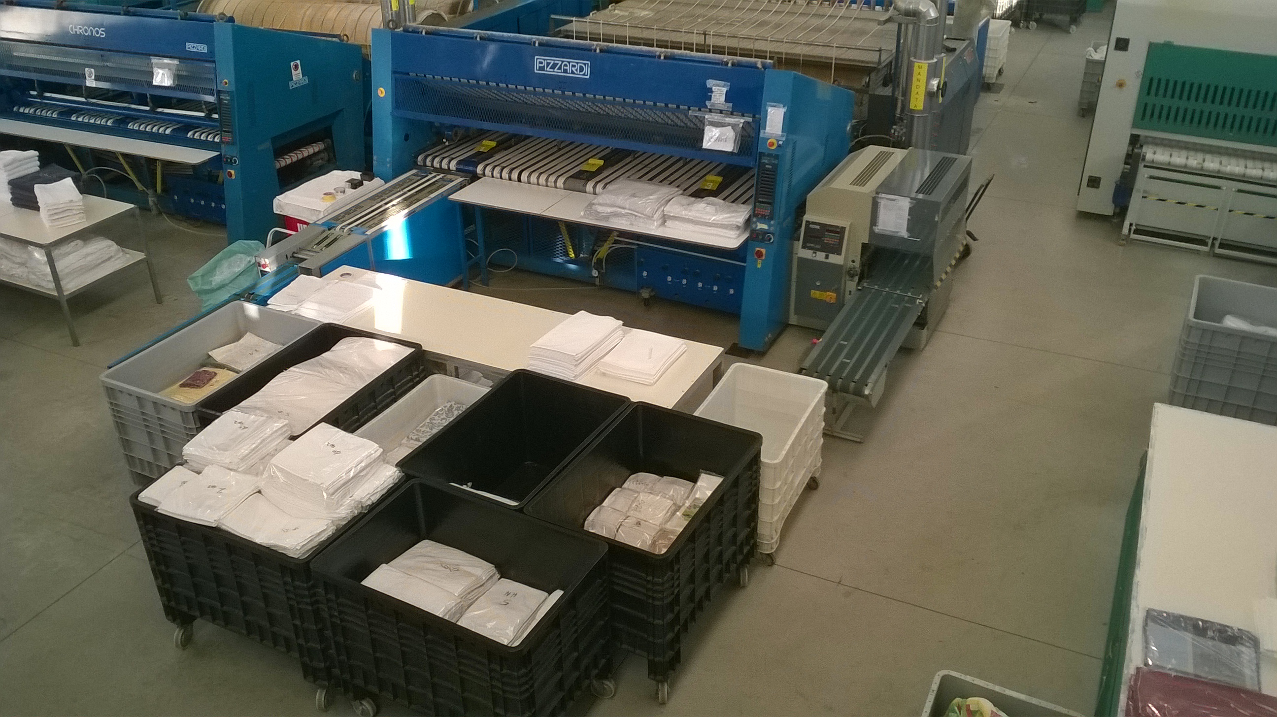 Sala macchinari con lavatrici industriali di grande capacità e sistemi di controllo automatizzati